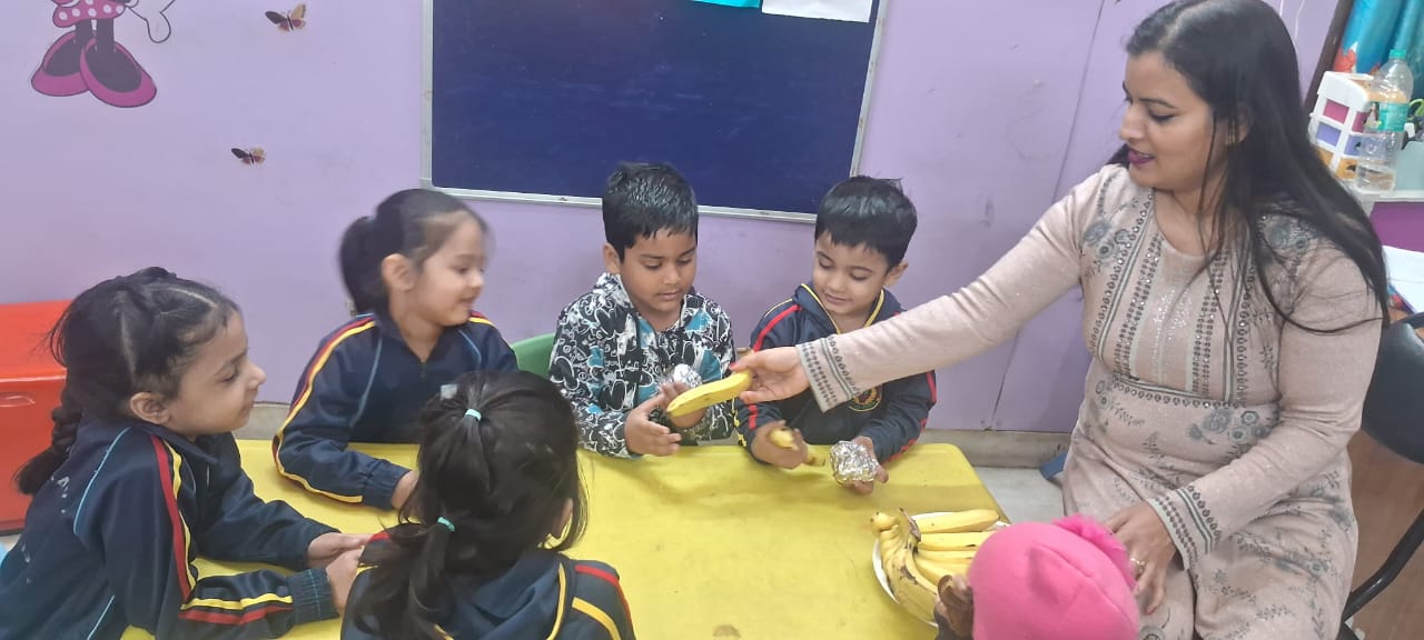 Young child sitting with snack plate in classroom